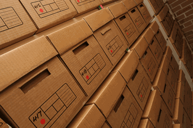 Stacked archive boxes neatly arranged in a storage unit.